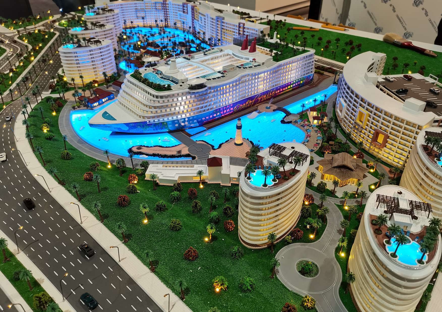 Illuminated development model with buildings, landscape and blue water features