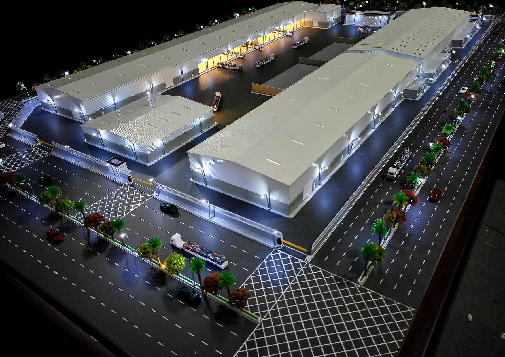 Illuminated industrial site scale model with buildings and access roads