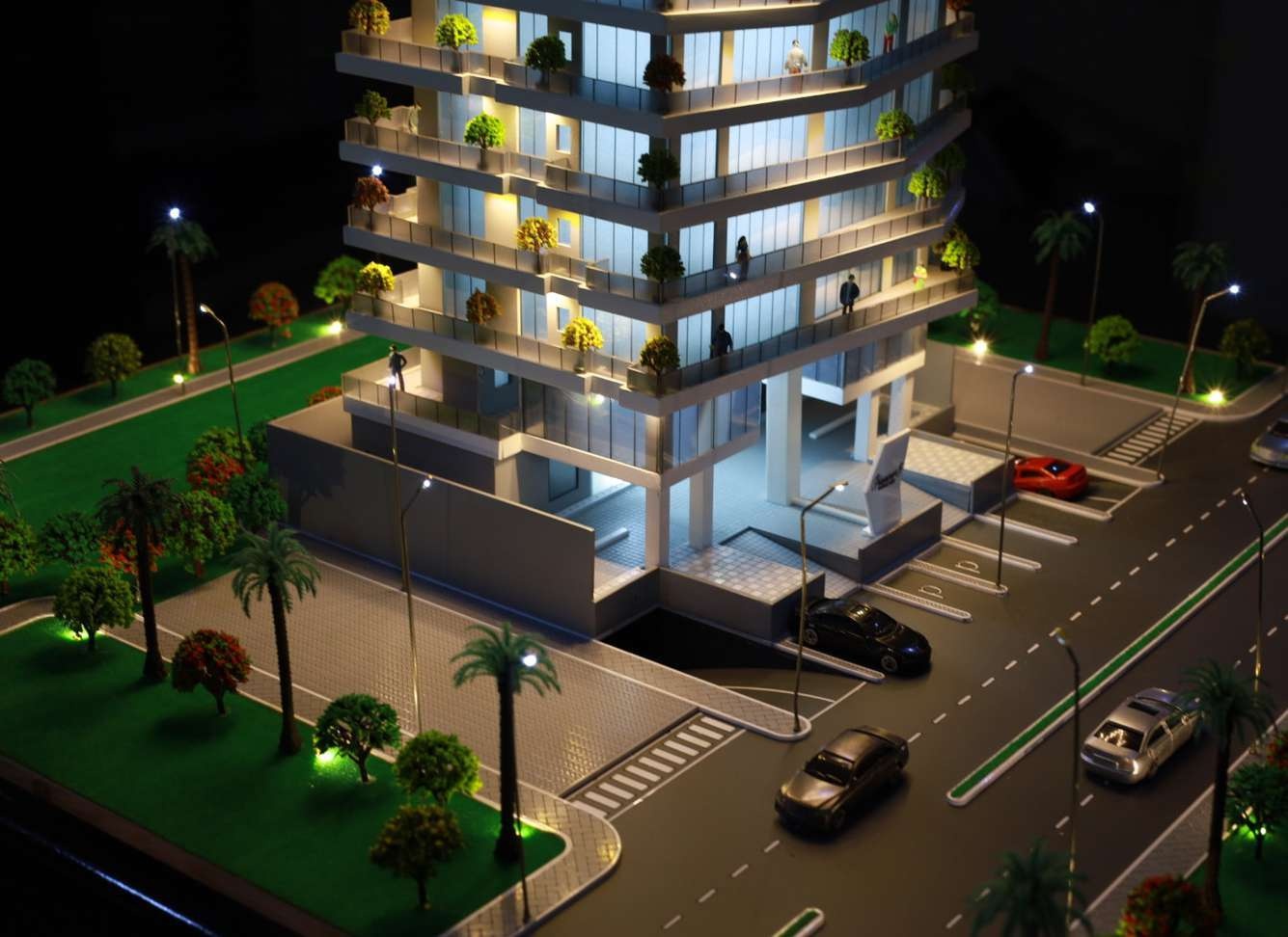 Illuminated architectural tower model with detailed entrance and landscaping
